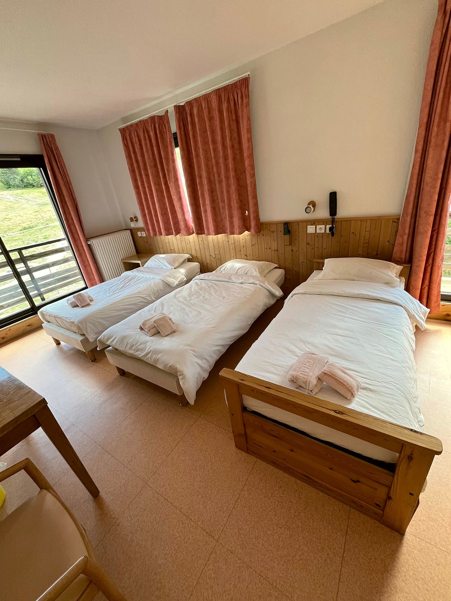 Chambre à deux lits d'un hébergement, refaite et prête à recevoir un client